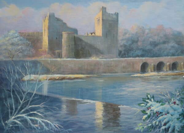 Cahir Castle stands majestically over a snowy river, framed by frosty trees and a hint of winter foliage in the foreground