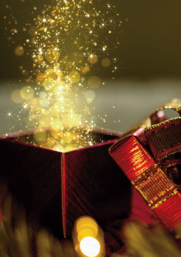 A red gift box with a shimmering golden glow and sparkles emerging from it, surrounded by festive decorations
